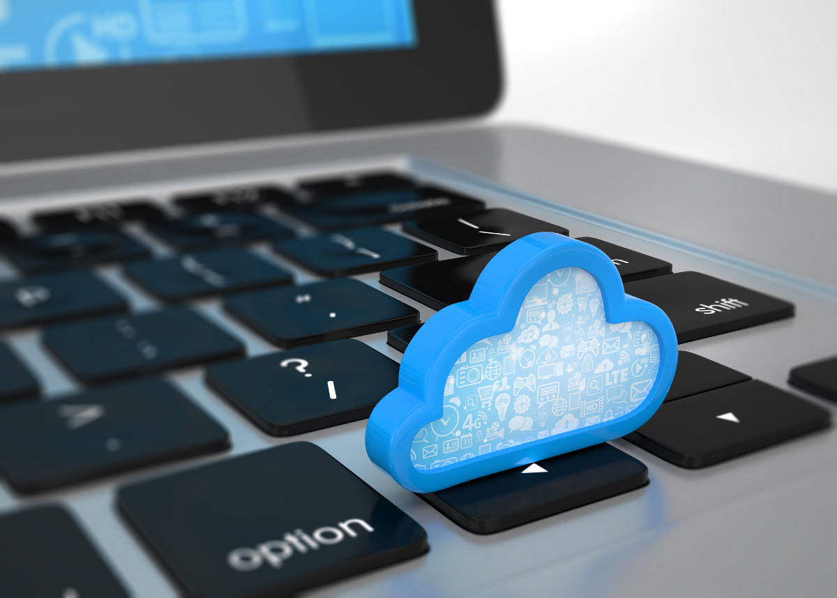 Blue cloud icon resting on a laptop keyboard