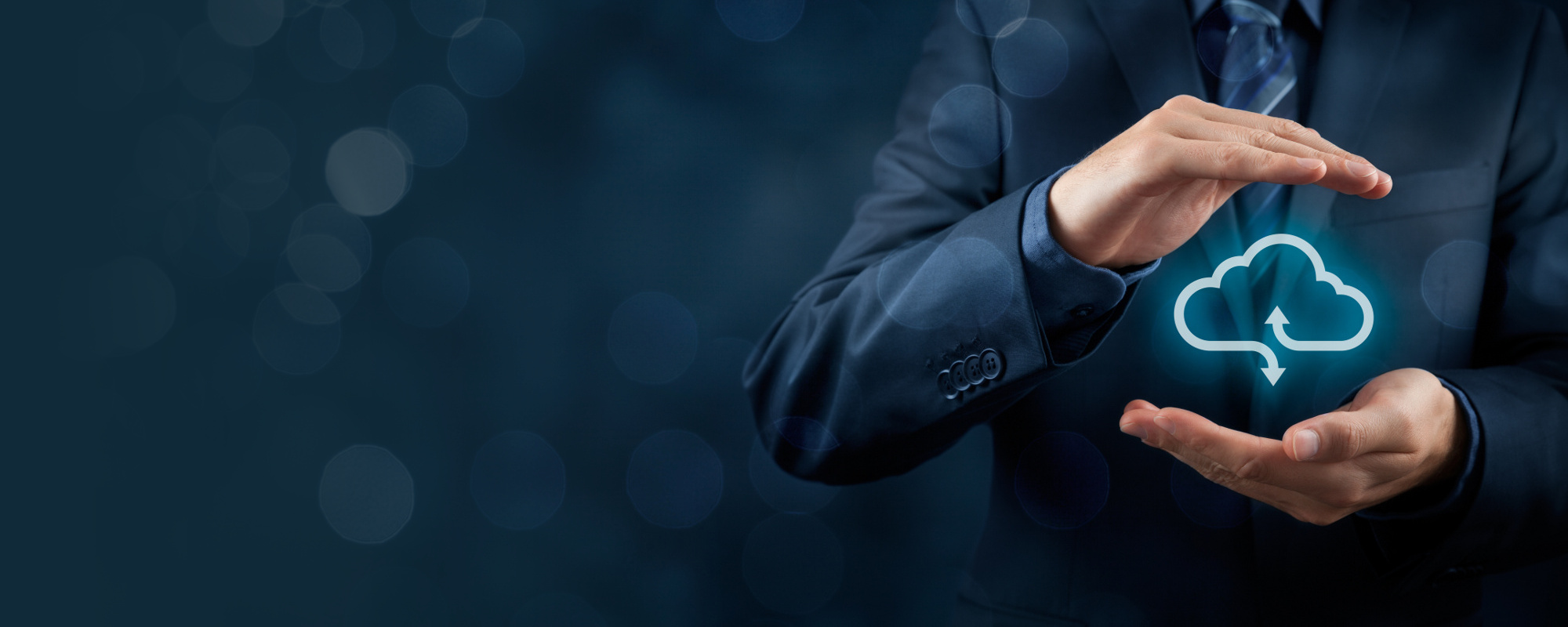 Businessman holding a glowing cloud upload icon between his hands